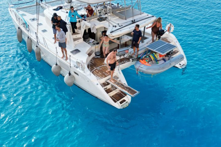 a blue and white boat sitting next to a body of water