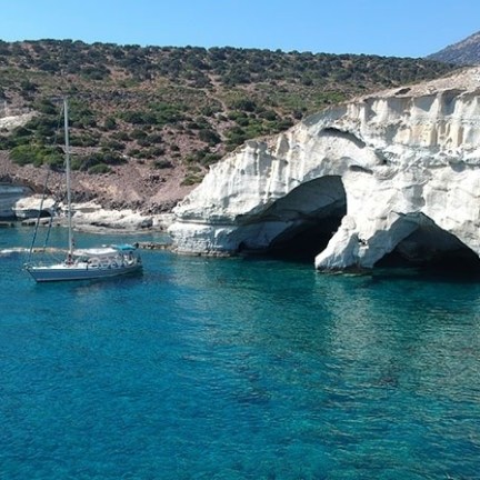 a small boat in a body of water with a mountain in the background