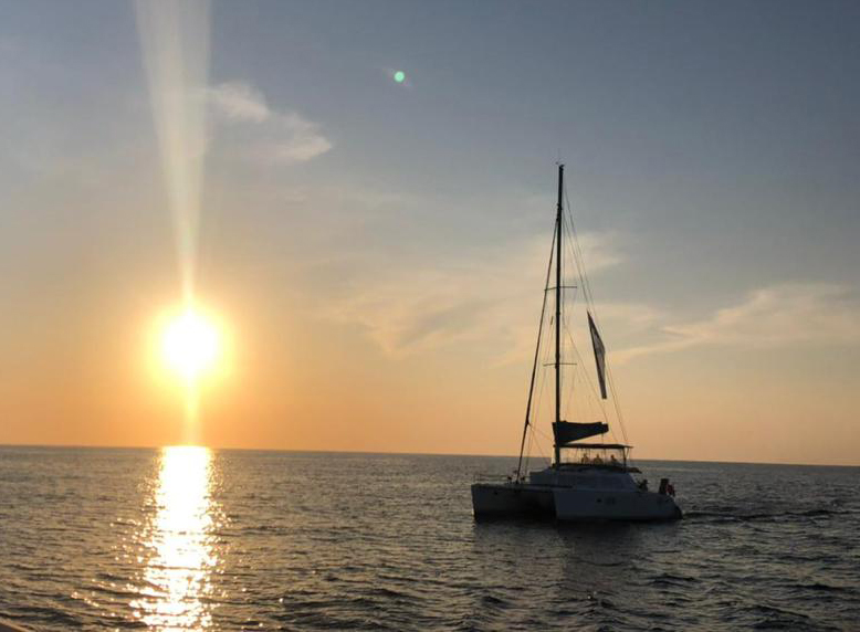 MIA SUNSET a small boat in a large body of water