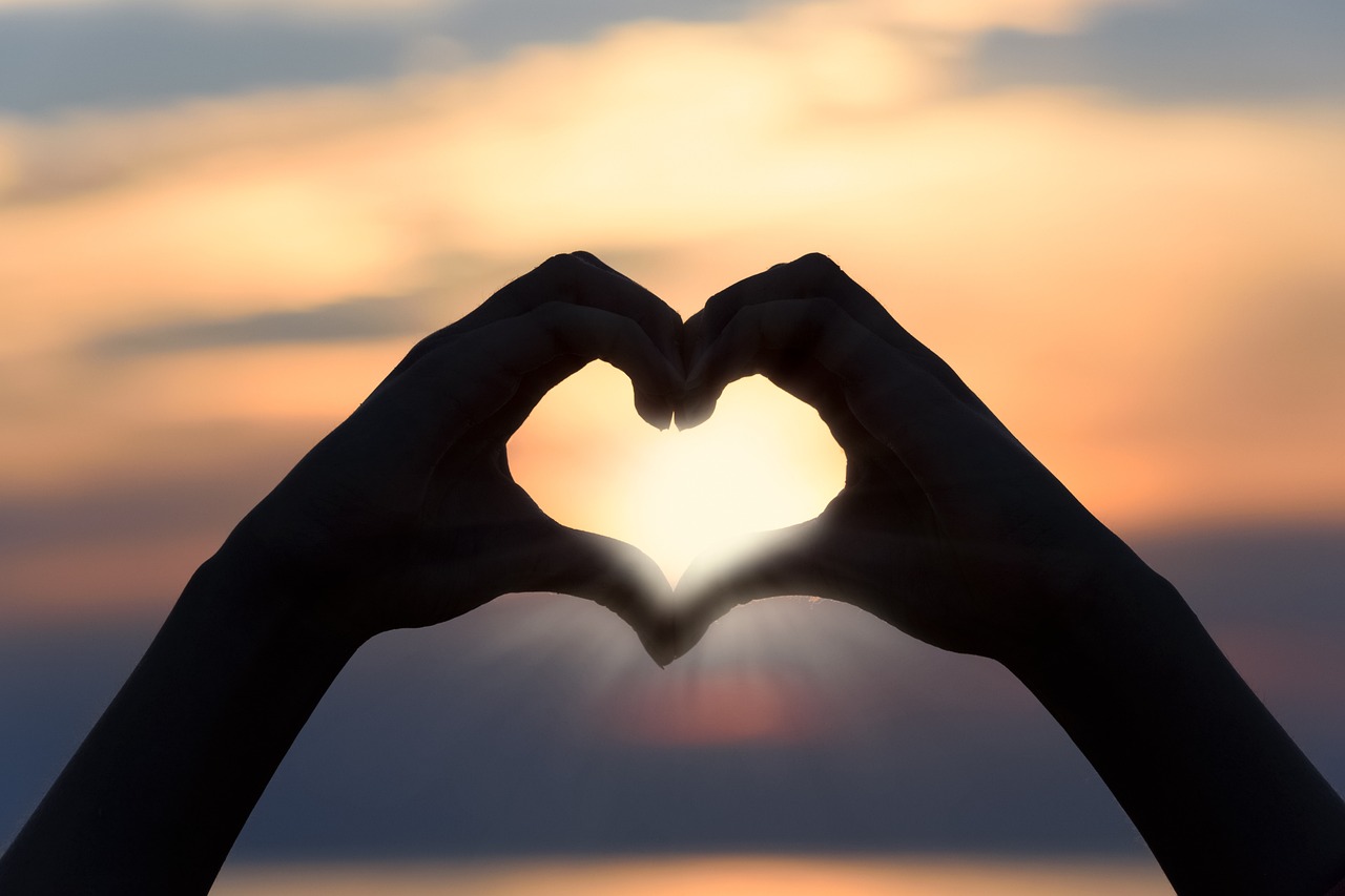 sunset-boat-tour-heart-3147976_1280 a close up of a hand with a sunset in the background