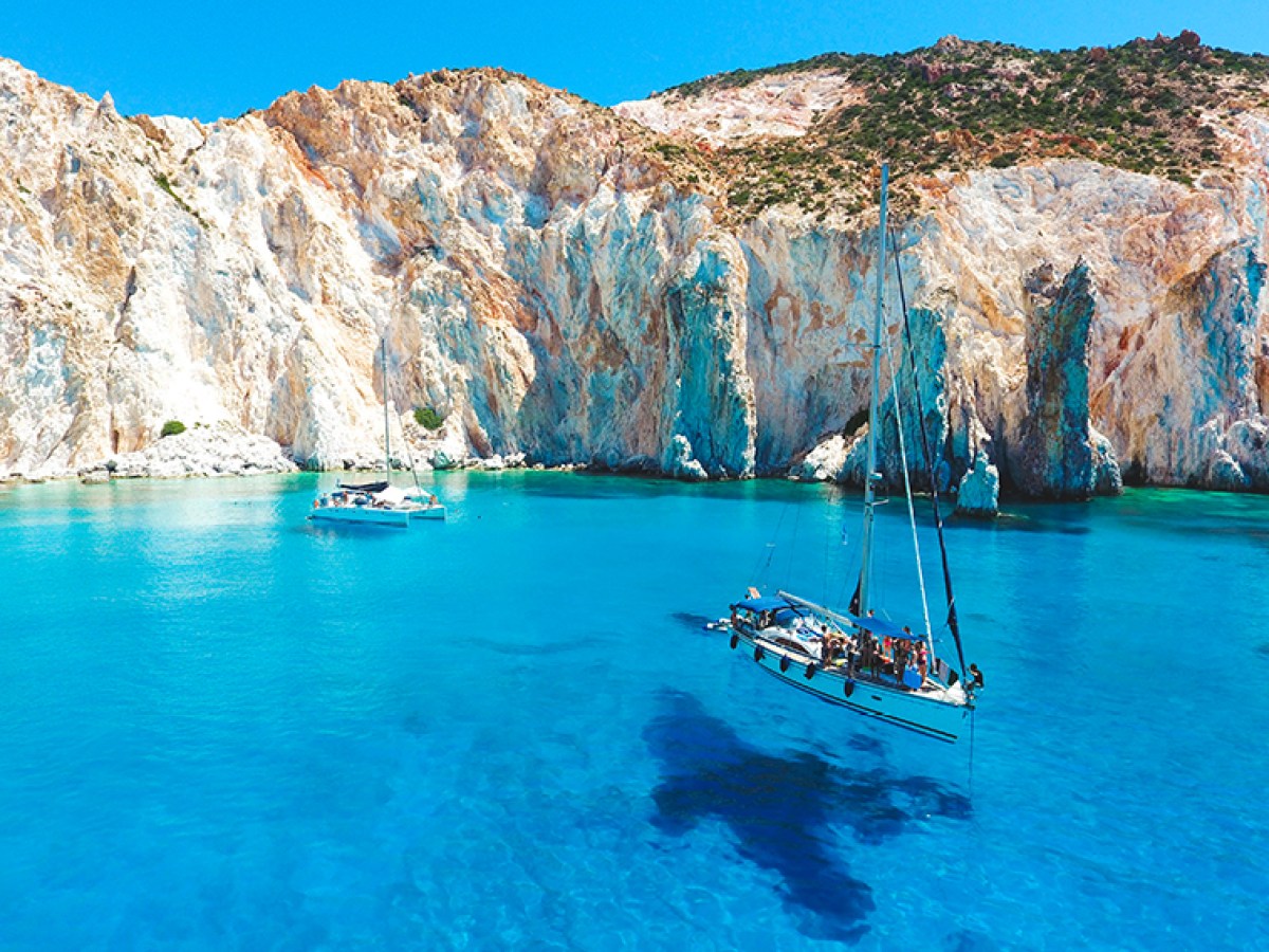 a small boat in a body of water with a mountain in the background