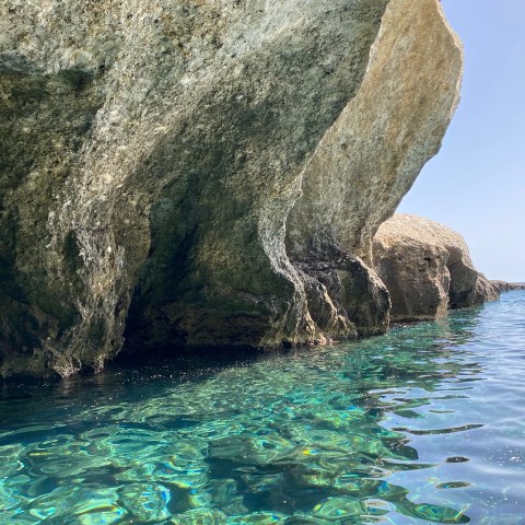 a close up of a rock next to a body of water