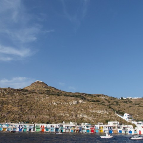 a group of people on a beach with a mountain in the background