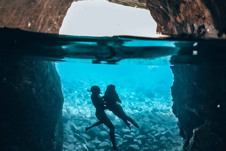Underwater photo of a couple in Sykia cave in Milos on a Polco sailing cruise